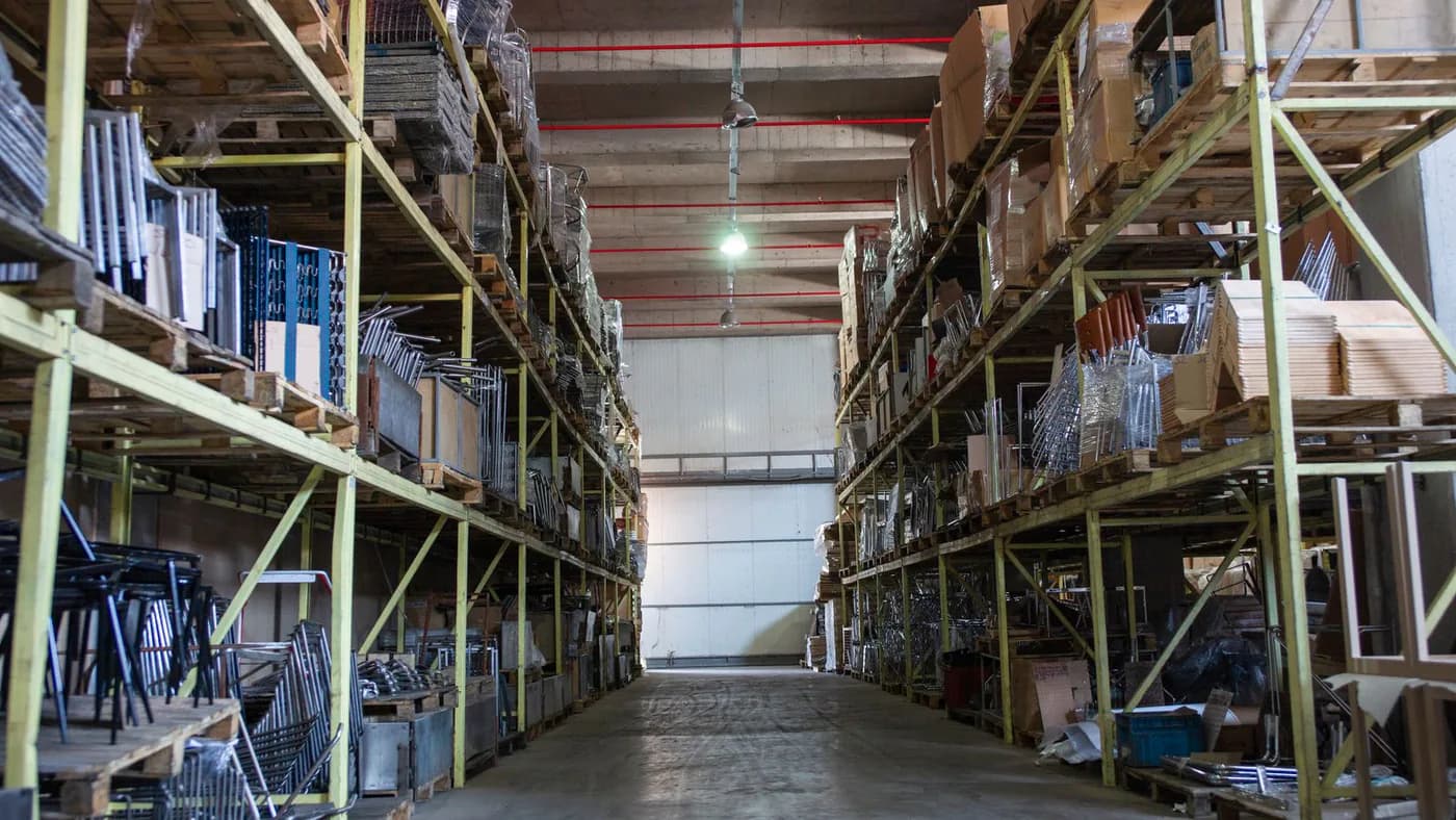 Organised storage aisle with pallet racking and shelving installed in an industrial warehouse